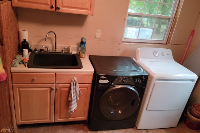 laundry room featuring independent washer and dryer, sink, and cabinets