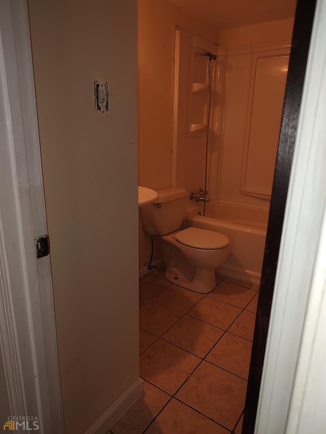 bathroom featuring tile floors, shower / washtub combination, and toilet