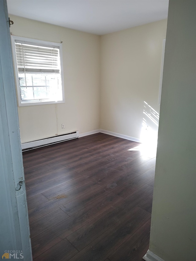 spare room featuring dark hardwood / wood-style floors and baseboard heating