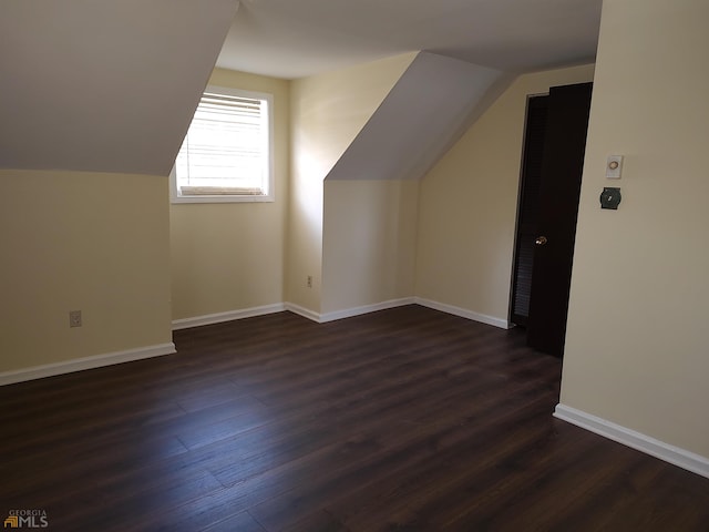 additional living space with dark hardwood / wood-style floors and vaulted ceiling