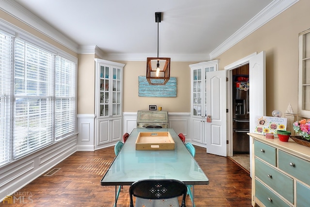 dining space featuring plenty of natural light, ornamental molding, and dark hardwood / wood-style floors