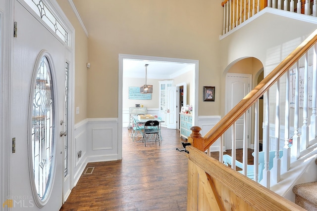 foyer featuring a high ceiling, crown molding, and dark wood-type flooring