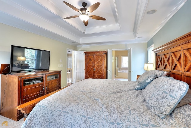 bedroom with crown molding, ensuite bath, and a tray ceiling