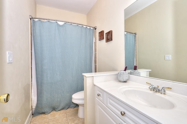 bathroom with toilet, tile floors, and vanity