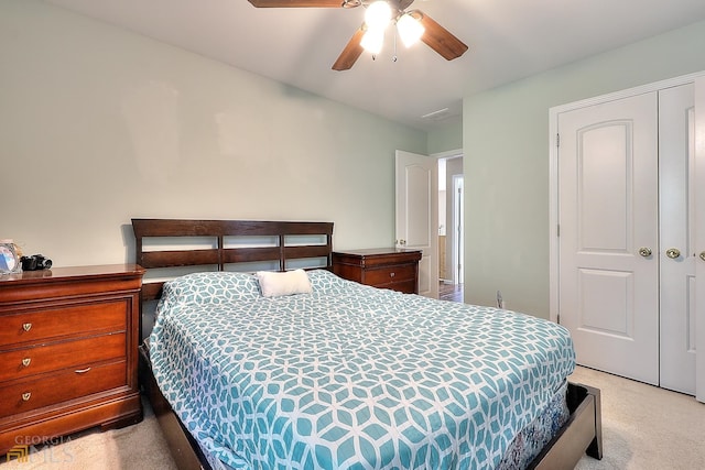 bedroom featuring a closet, light colored carpet, and ceiling fan