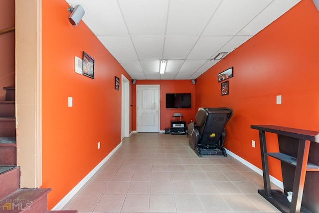 interior space featuring light tile flooring and a drop ceiling