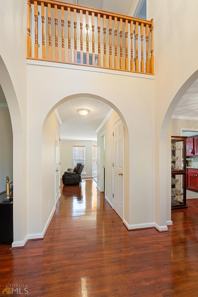 entrance foyer featuring crown molding, dark hardwood / wood-style floors, and a textured ceiling