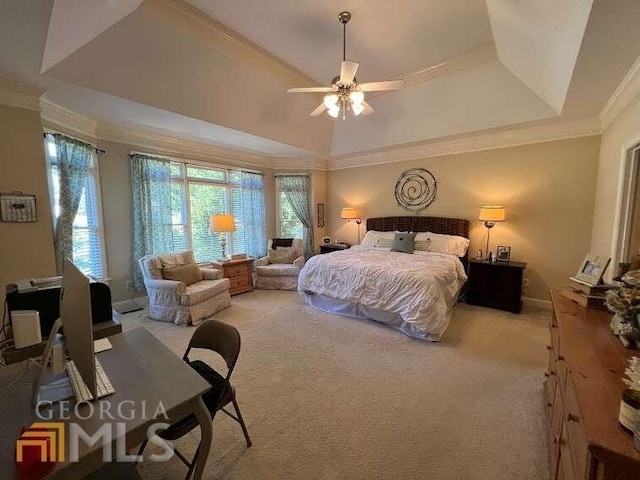 bedroom with crown molding, light colored carpet, ceiling fan, and a tray ceiling