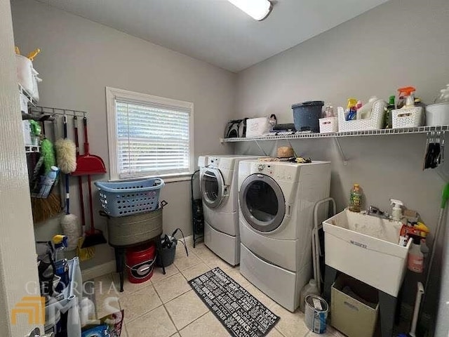 laundry area featuring independent washer and dryer, sink, and light tile floors