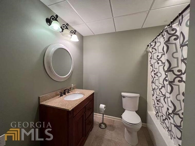 full bathroom with vanity, tile floors, shower / bathtub combination with curtain, a paneled ceiling, and toilet