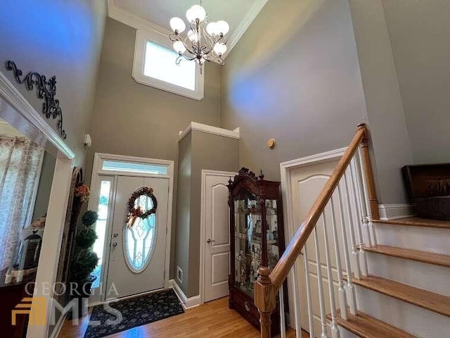 foyer featuring an inviting chandelier, a high ceiling, and light hardwood / wood-style flooring