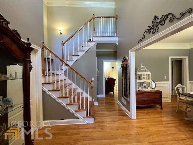 foyer with ornamental molding and light hardwood / wood-style flooring