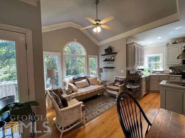 living room featuring plenty of natural light, ornamental molding, ceiling fan, and light hardwood / wood-style flooring