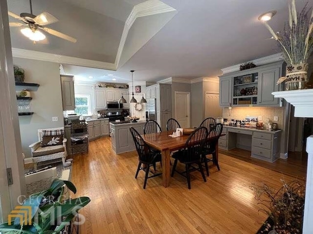 dining room with ceiling fan, ornamental molding, light hardwood / wood-style floors, and vaulted ceiling