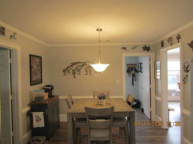 dining area featuring dark hardwood / wood-style flooring and crown molding