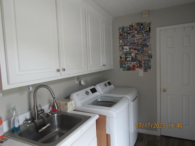 washroom featuring dark hardwood / wood-style flooring, washing machine and dryer, cabinets, and sink