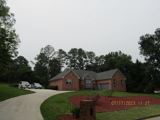 ranch-style house featuring a front yard and a garage