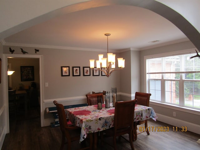 dining room with dark hardwood / wood-style flooring, ornamental molding, and a chandelier