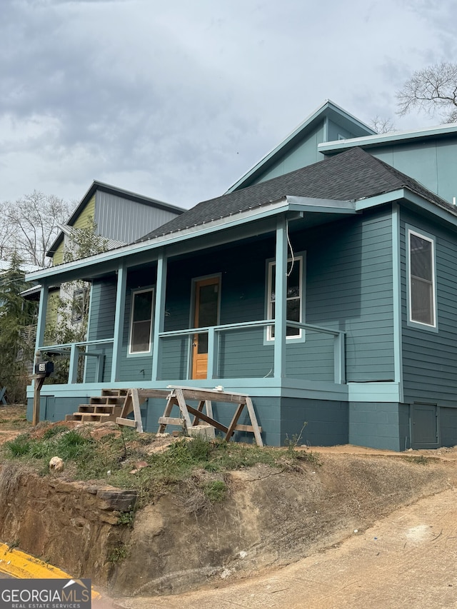 view of front of property with a porch and roof with shingles