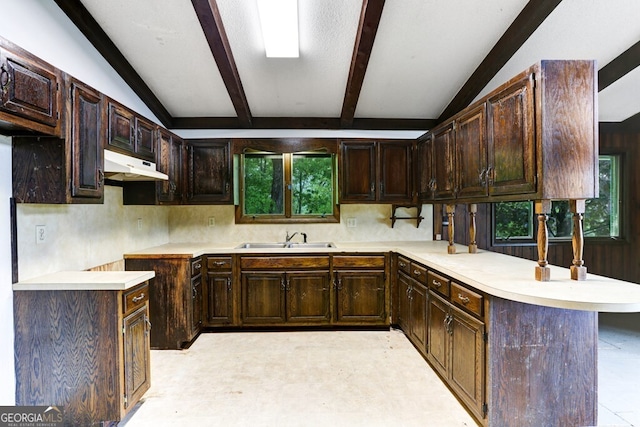 kitchen with a healthy amount of sunlight, lofted ceiling with beams, and light tile flooring