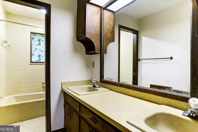 bathroom with tile floors, tiled shower / bath, and double vanity