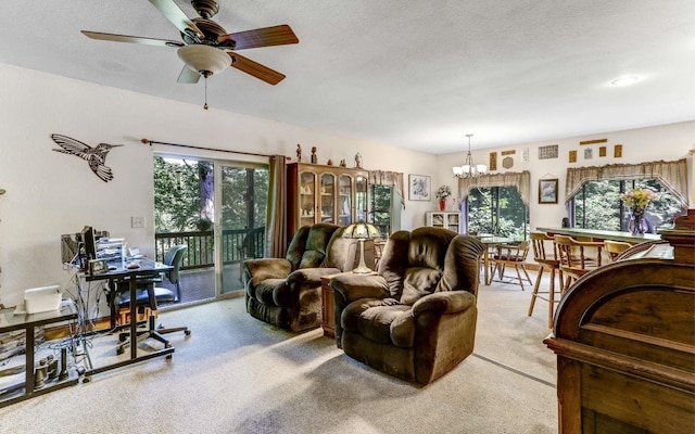 living room with a textured ceiling, ceiling fan with notable chandelier, a wealth of natural light, and light carpet