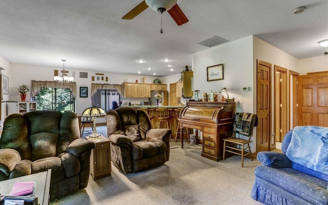 carpeted living room with a textured ceiling and ceiling fan with notable chandelier