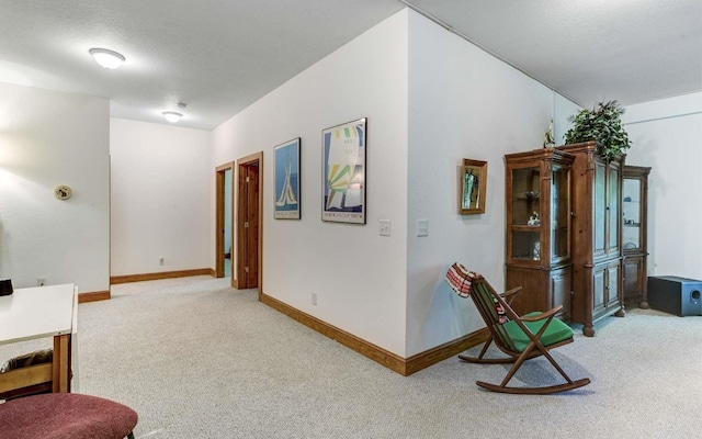 living area with a textured ceiling and light colored carpet