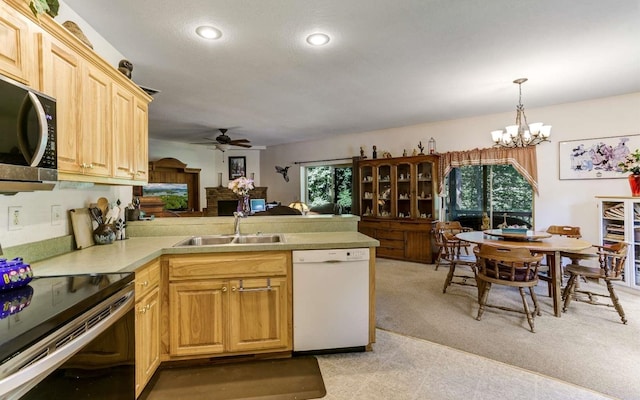 kitchen with sink, light tile floors, range with electric stovetop, white dishwasher, and ceiling fan with notable chandelier