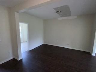 unfurnished room featuring dark wood-type flooring