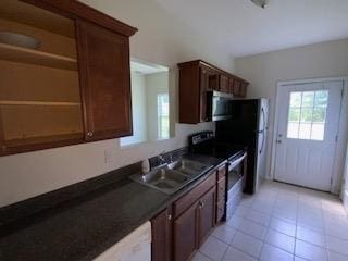 kitchen with light tile patterned floors, appliances with stainless steel finishes, and sink