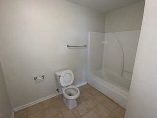 bathroom featuring toilet, tile patterned floors, and shower / tub combination