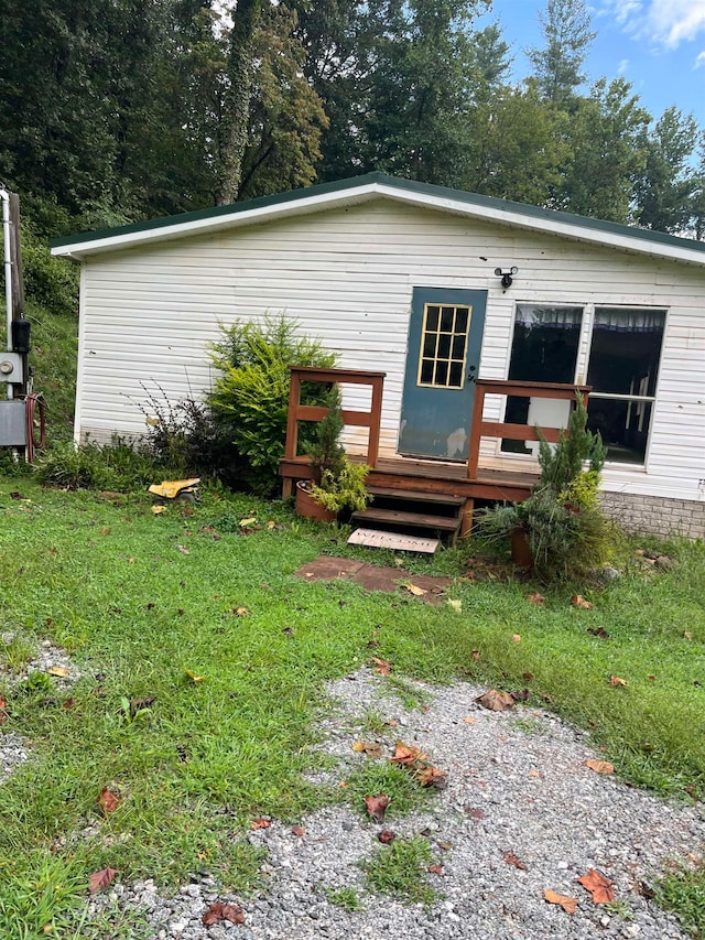 rear view of property with a deck and a lawn