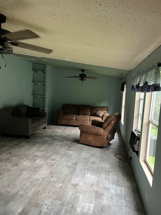 living room featuring light hardwood / wood-style flooring, a textured ceiling, and ceiling fan