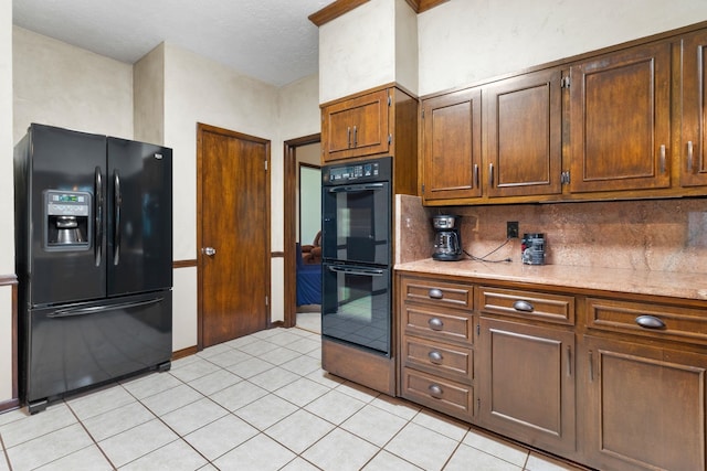 kitchen featuring backsplash, light tile floors, and black appliances