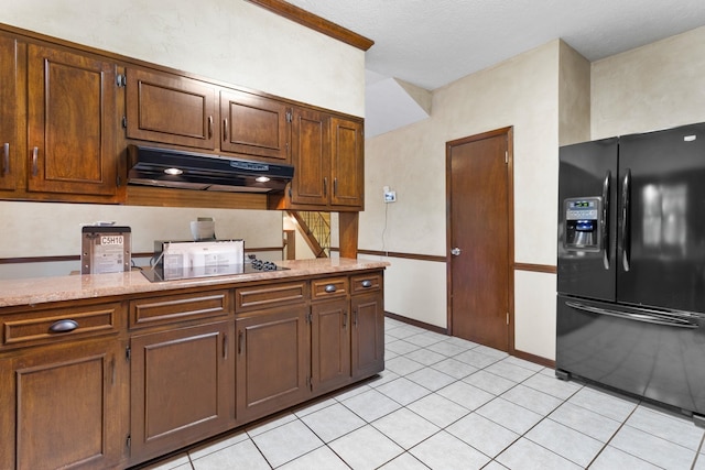 kitchen with light stone countertops, light tile floors, and black appliances