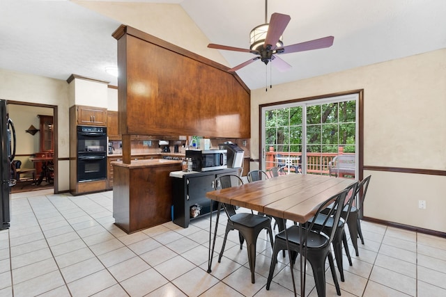 tiled dining area featuring vaulted ceiling and ceiling fan