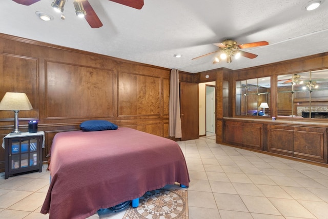 bedroom featuring a textured ceiling, ceiling fan, and light tile floors