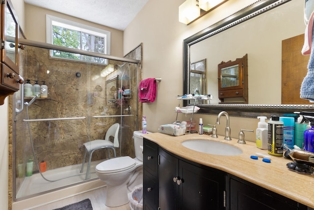 bathroom featuring walk in shower, toilet, a textured ceiling, and large vanity