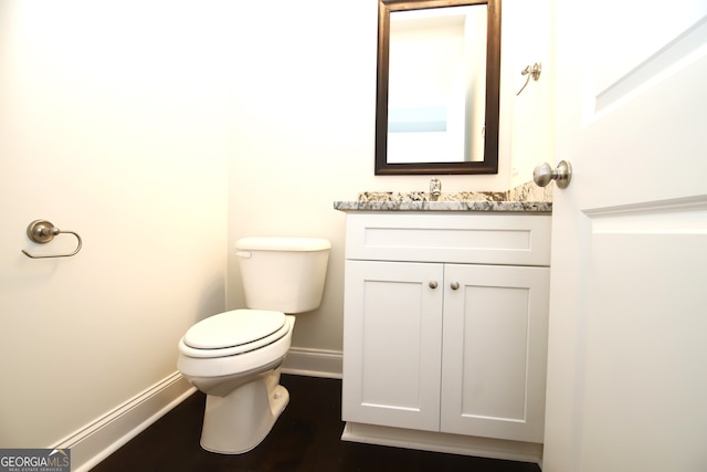 bathroom with toilet, vanity, and hardwood / wood-style floors