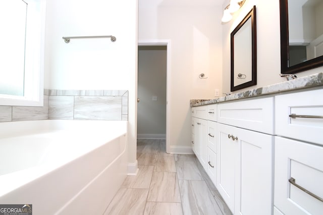 bathroom with tile flooring, a bathing tub, and large vanity