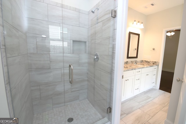 bathroom featuring walk in shower, tile flooring, and vanity