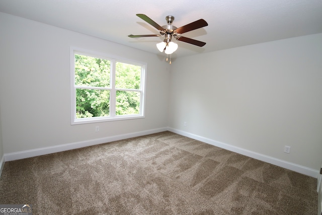 carpeted spare room featuring ceiling fan