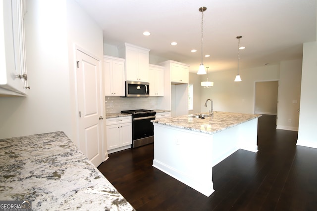 kitchen with dark wood-type flooring, white cabinetry, stainless steel appliances, sink, and an island with sink