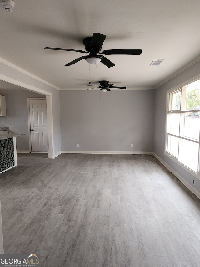 empty room featuring crown molding, dark hardwood / wood-style flooring, and ceiling fan