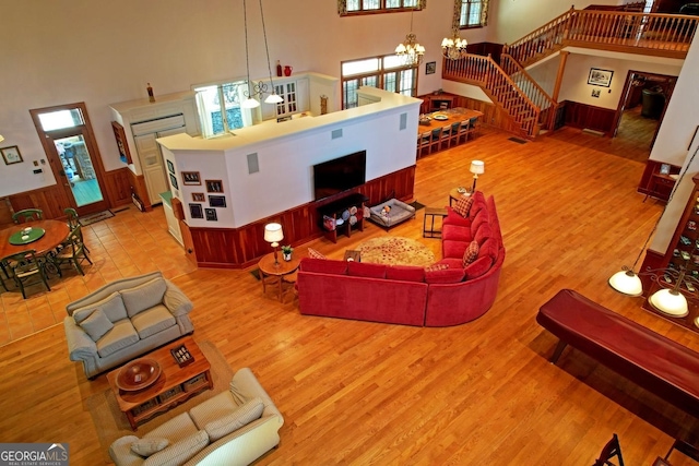 living room with a high ceiling, a notable chandelier, and wood-type flooring