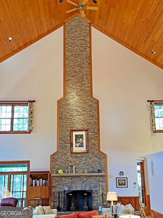 interior space with a stone fireplace, high vaulted ceiling, and a wealth of natural light