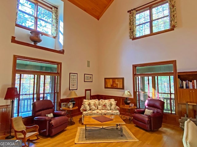 living room with light wood-type flooring, a high ceiling, and a wealth of natural light