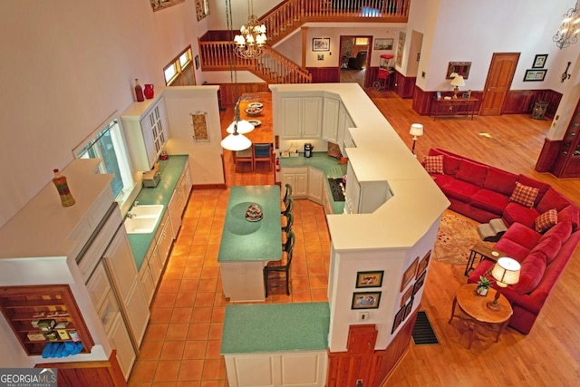 rec room with sink, a high ceiling, a chandelier, and light tile floors