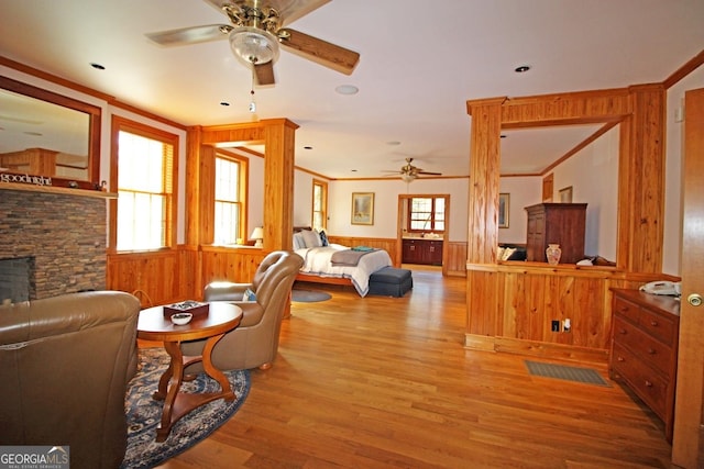 living room with plenty of natural light, ceiling fan, light wood-type flooring, and a fireplace